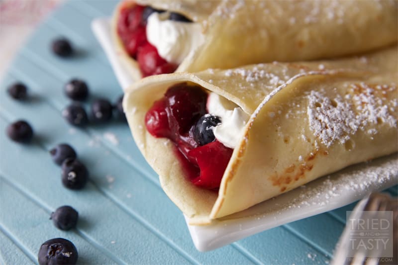 Close up view of cherry blueberry breakfast crepes.